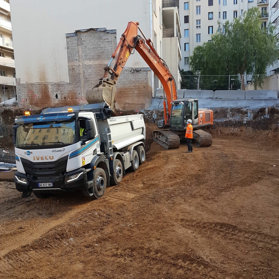 pelleteuse remplissant un semi de terre polluée sur un chantier de terrassement à Toulon